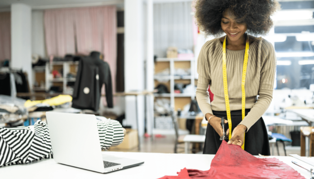 African fashion designer cutting a piece of cloth