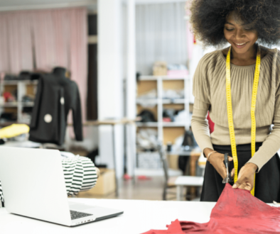 African fashion designer cutting a piece of cloth