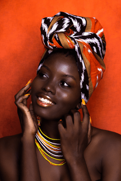 Portrait of a Woman in African Accessories on Orange Background